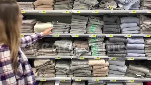 女人从架子上拿毛巾年轻女孩在超市买东西4K慢慢视频的预览图