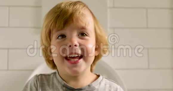微笑的孩子在浴室里看着视频的预览图