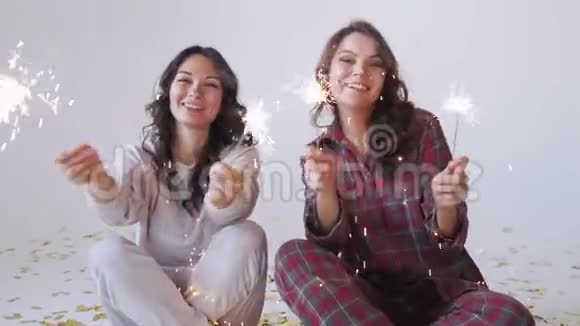 两个穿着睡衣的漂亮女人带着火花庆祝圣诞节视频的预览图
