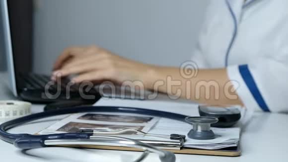 女医生在电脑上工作在笔记本电脑上打字在电脑上填写数据视频的预览图