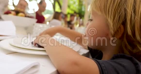 在外面餐馆的餐桌上吃葡萄的好奇儿童视频的预览图