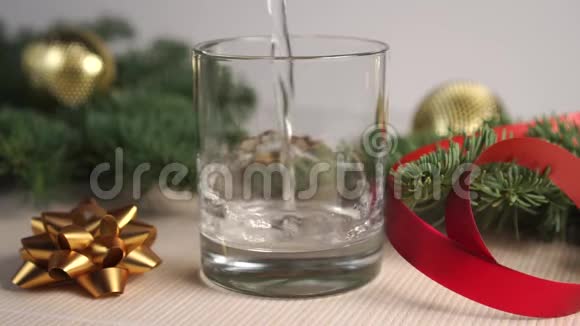 透明透明的液体气泡和倒入玻璃上的桌子上上面有云杉枝和圣诞装饰视频的预览图