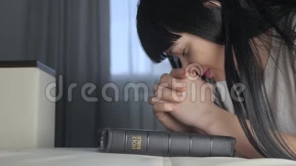 女孩在睡前祈祷圣经生活方式宗教观念晚祷信徒女人深色手视频的预览图