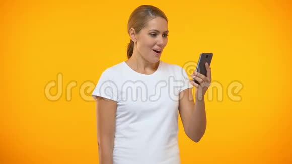 年轻女子在看智能手机信息时显示是的手势好消息打赌视频的预览图