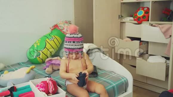 帽子里可爱的宝宝看着Messy房间里的T恤视频的预览图
