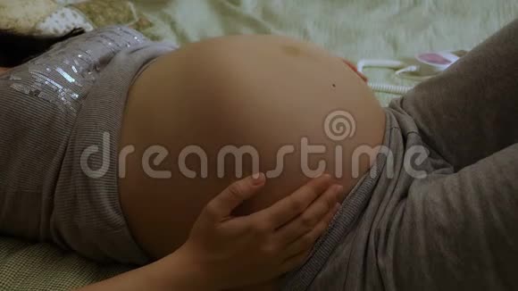 孕妇用多普勒听婴儿心跳孕妇抚摸着她的胃视频的预览图