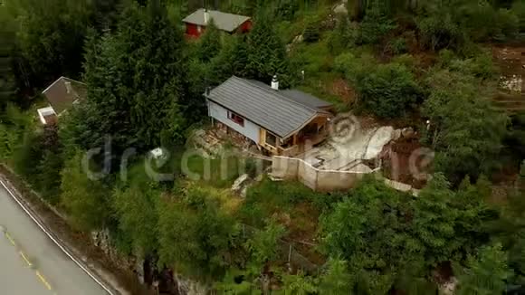 鸟瞰一个小村庄位于茂密的森林中的山坡上挪威渔业村视频的预览图