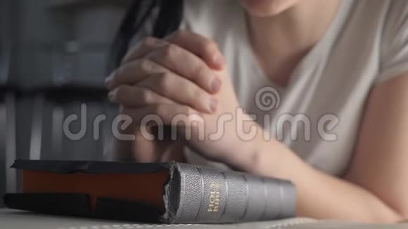女孩在睡前用圣经在室内祈祷宗教概念晚祷妇女深色手圣经祈祷视频的预览图