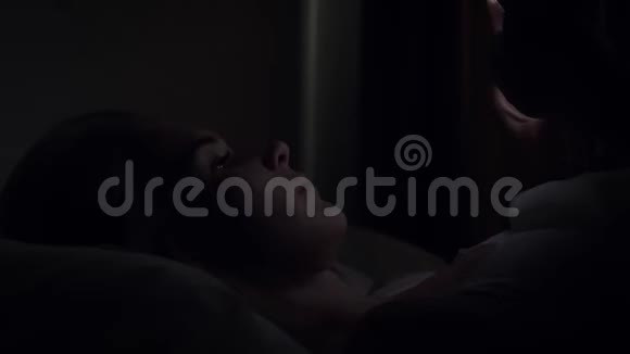 女人晚上睡觉前在床上用智能手机视频的预览图