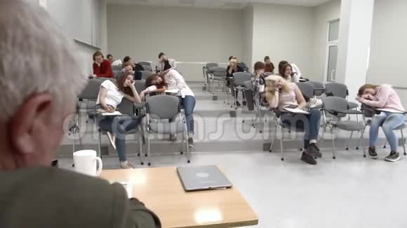 一群学生在大学里睡觉教授坐在桌子旁视频的预览图