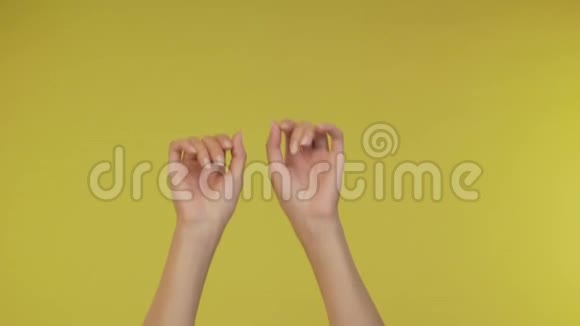 优雅的女性手在黄色背景上进行音乐孤立背景4K视频的预览图
