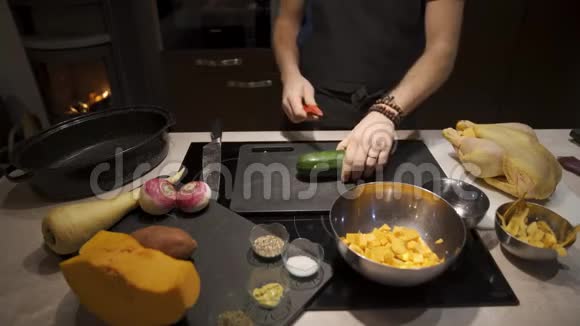 男人用剥皮蔬菜准备晚餐视频的预览图