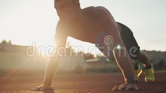 一位年轻的肌肉健美运动员用杠铃举臂的特写侧景视频的预览图