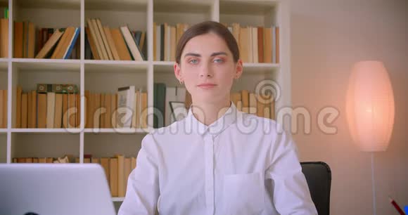一位年轻的高加索女商人的特写肖像她正兴高采烈地坐在笔记本电脑前看着摄像机视频的预览图