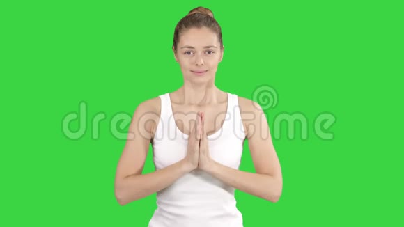 年轻的瑜伽女性练习瑜伽做一个新的手势锻炼身体穿着绿色屏幕上的白色t恤Chroma视频的预览图