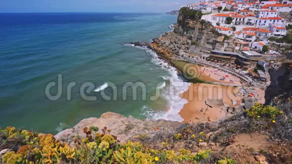 4K可爱的海滩在风景如画的村庄AzenhasDoMar在悬崖边缘有海浪景观的粉笔建筑辛特拉视频的预览图
