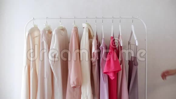 白色衣架上穿粉色米色和奶油色的女式服装视频的预览图