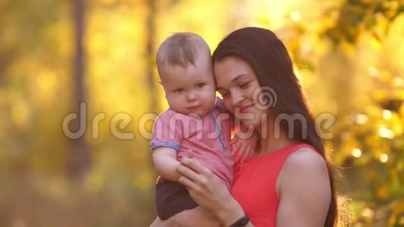 日落时带着孩子微笑的母亲视频的预览图