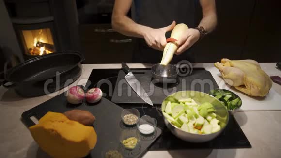 男人用剥皮蔬菜准备晚餐视频的预览图