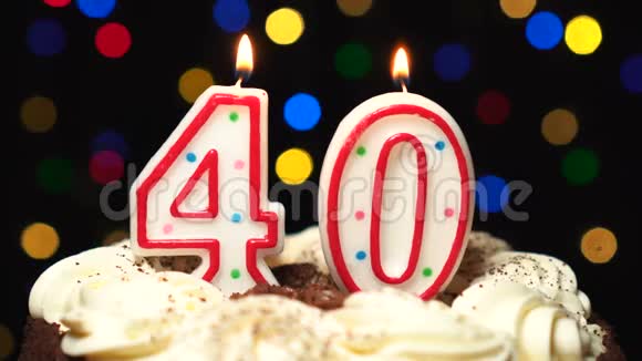 在蛋糕上面的40号40岁生日蜡烛燃烧在最后吹灭彩色模糊背景视频的预览图