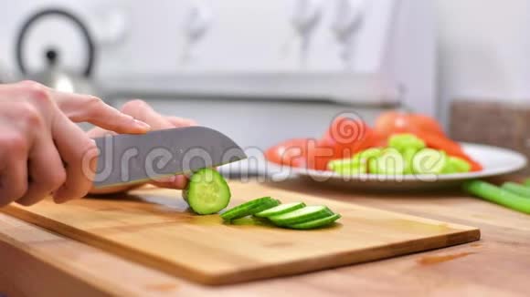 女人用菜刀在木板上切鲜黄瓜视频的预览图