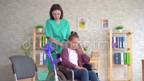 按摩师医生给坐轮椅的十几岁女孩做颈部按摩视频的预览图
