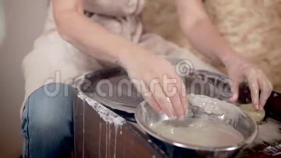 年轻女孩在车轮上做陶器视频的预览图