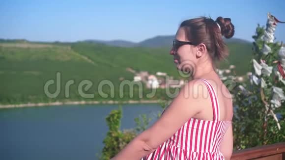 戴眼镜的漂亮黑发女人走在海拔高度附近的一个山湖景色惊人女人喜欢看风景视频的预览图