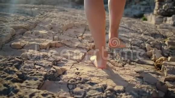 光着脚在海岸岩石上行走视频的预览图