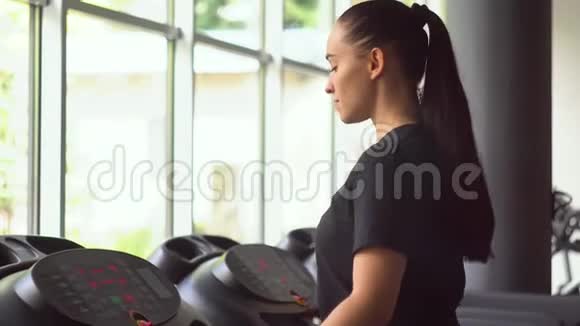 在健身房跑步机上跑步的漂亮女孩视频的预览图