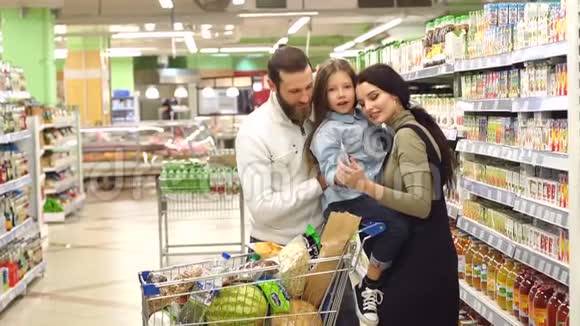 在超市里有女儿的年轻家庭肖像他们为孩子买果汁视频的预览图