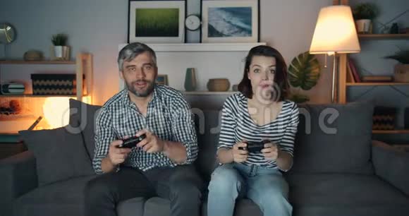 女孩和男人深夜在家玩电子游戏女人赢了视频的预览图