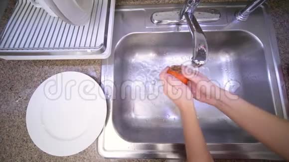 女人正在厨房的水槽里用自来水洗柿子视频的预览图