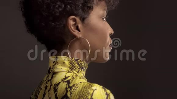 混血非裔美国妇女穿着亮黄色连衣裙和蟒蛇印花90的风格视频的预览图