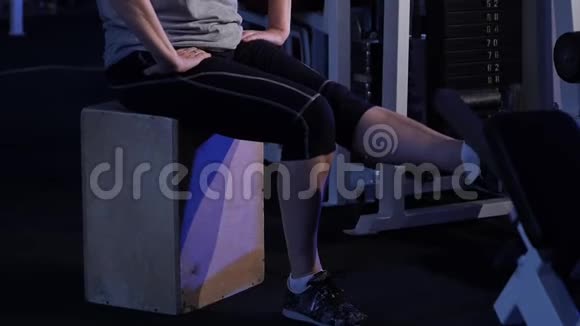以坐姿伸展膝盖处的腿一位年长的女子练习关节体操复制空间侧视视频的预览图