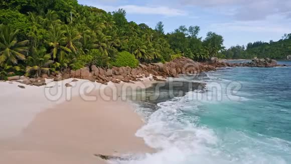 在塞舌尔的马河岛高空4K低空飞越异国热带海滩有岩石棕榈树和海浪视频的预览图