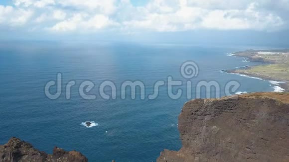 大西洋上空陡峭悬崖的鸟瞰图从Puntdel观景台飞过欣赏美景的人们视频的预览图