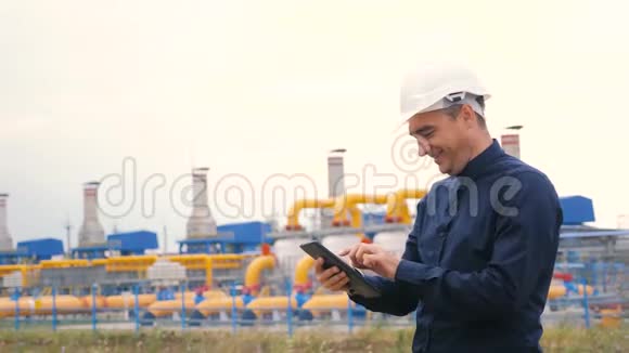 开采油气生产行业理念工程师人力和能源使用数字平板电脑戴头盔的工人视频的预览图