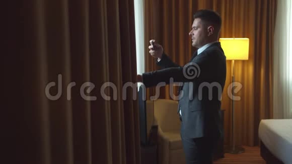 穿夹克的男人在酒店房间打电话拍照视频的预览图