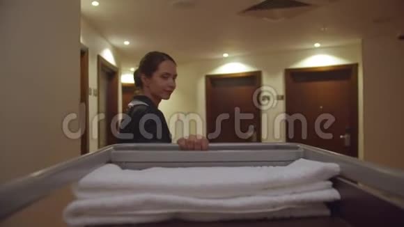 从背面看女佣用清洁设备穿过酒店走廊视频的预览图
