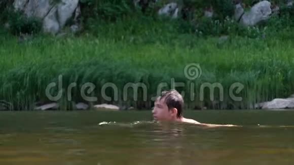 少年沿着河游过芦苇向右向左游去夏日的乐趣假期和旅行视频的预览图