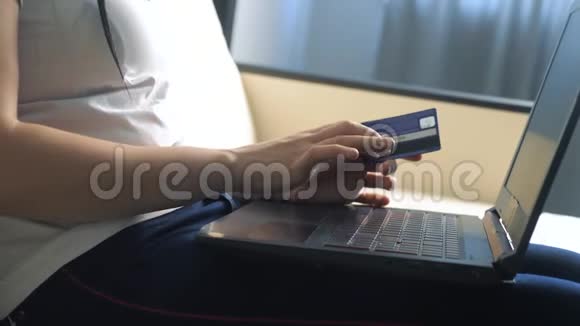 女孩用笔记本电脑数字平板电脑制作网上销售购物概念黑发女人躺在生活沙发上看着商店视频的预览图