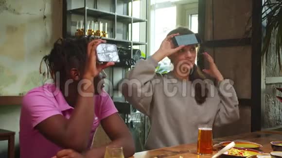 朋友坐在咖啡馆里玩电话游戏女人解释一个词视频的预览图