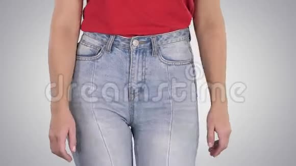 休闲女性穿着高牛仔裤和红色t恤在渐变背景下行走视频的预览图