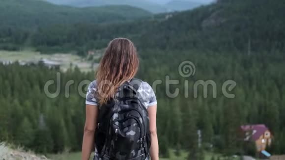 穿着短裤背包的女旅行者站在山顶举起双手目标的实现慢慢慢慢视频的预览图