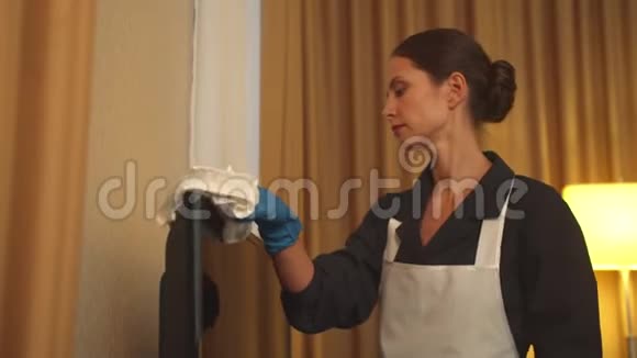 旅馆房间里的胡塞梅德戴着手套用抹布擦拭电视视频的预览图