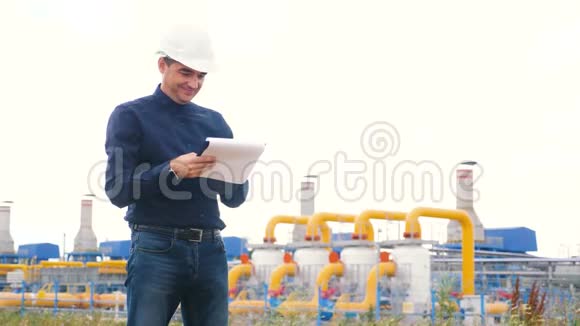 工程师生活方式男子动力和能源使用数字平板电脑戴头盔的工人在石油天然气厂工作工程师视频的预览图