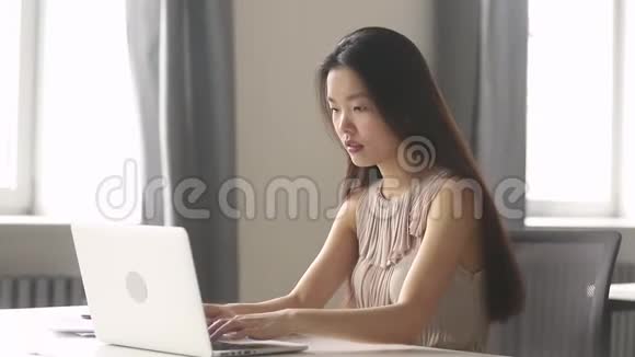 兴奋的亚洲女商人赢家庆祝在线赢看笔记本电脑视频的预览图