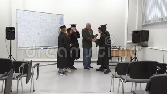 毕业生们微笑着和他们的教授握手视频的预览图