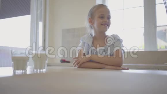 这位母亲在女儿面前的桌子上放了新鲜出炉的蛋糕快乐的女孩抓了一个蛋糕视频的预览图